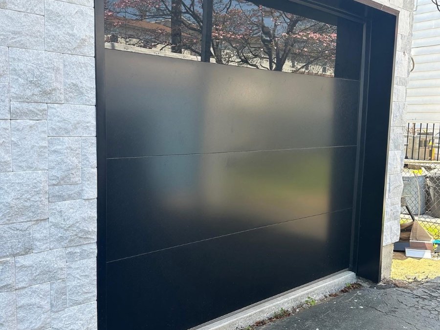 Black full-view glass garage door on a modern home in New Jersey