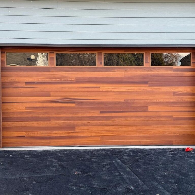 Modern wood-look garage door with glass top panels installed by NJ Garage