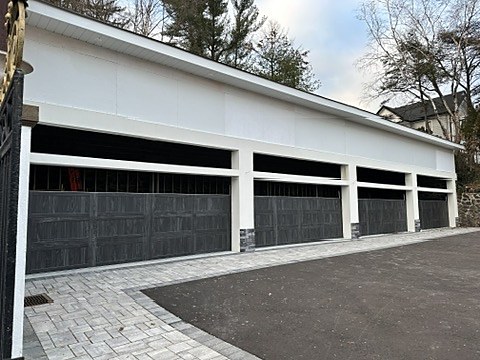 Black doors on a multi-bay garage installed by NJ Garage in River Edge, NJ
