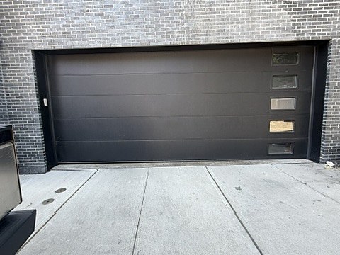 Black flush door with vertical windows installed by NJ Garage in North Bergen, NJ