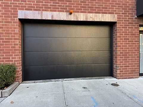 Black flush garage door installed by NJ Garage in Hoboken, NJ
