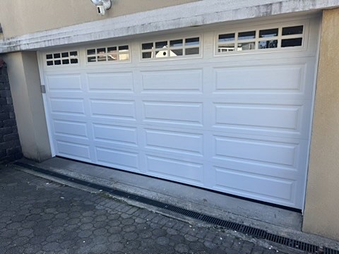 White raised-panel double door with windows installed by NJ Garage in Ridgefield, NJ